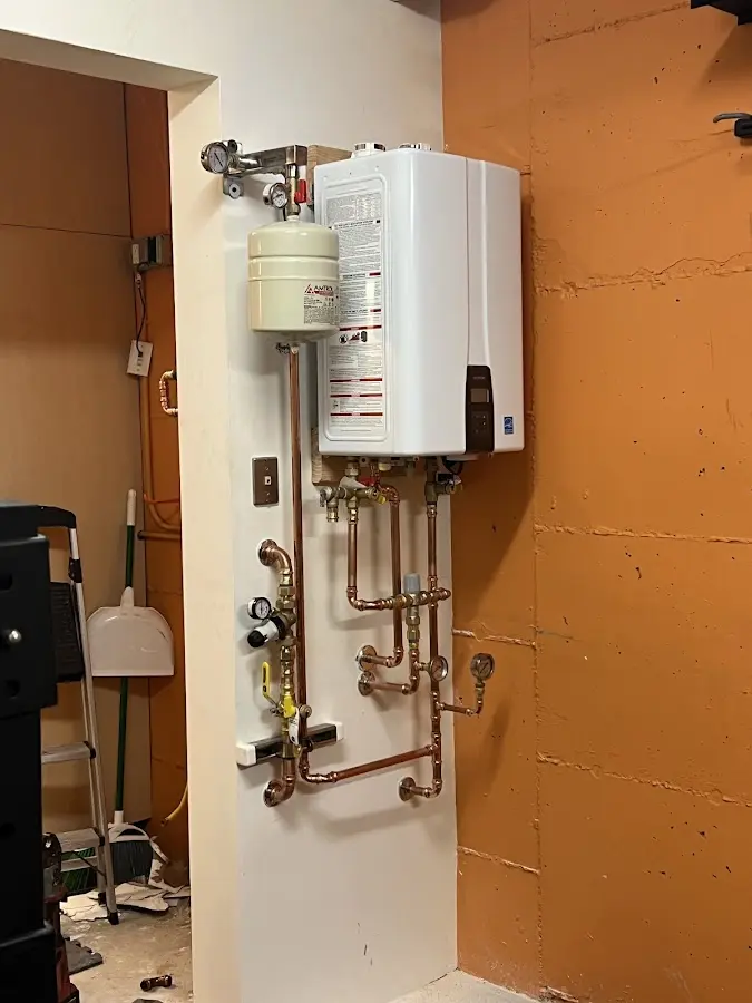 Plumbing technician inspecting water heater connections in Lakehills